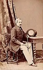 Portrait en pied, assis sur une chaise devant une table chapeau haut de forme et canne. Attention il s'agit de Chevandier et nom de Forcade Laroquette comme le libellé de l'image.jpg le laisse croire.