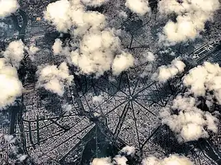 Vue aérienne des douze grandes avenues rayonnant autour de la place Charles-de-Gaulle, visible au centre de l'image.