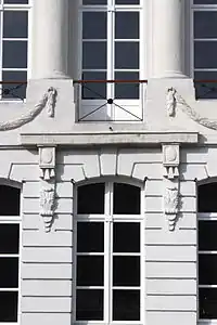 Immeuble d'angle vers la rue Saint-Michel : balcon reposant sur des consoles et entouré de guirlandes de laurier.