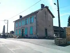 Vue sur le côté sud-est de la mairie depuis la place du Pilori, l’inscription peinte « École des Filles » est encore visible sur le mur sud-est