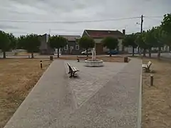 La place du village, située de l'autre côté de la rue par rapport à la mairie.