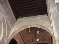 Photographie d'une partie du plafond en bois à solives apparentes de la nef centrale de la salle de prière.