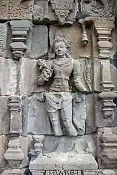 Photographie du bas-relief d'une divinité hindoue en quatre parties : la tête, le buste, les jambes et les pieds.