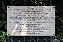 Plaque contre le square commémorant l'immigration ukrainienne en France, faisant notamment mention de la cathédrale Saint-Volodymyr-le-Grand adjacente.