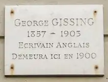 Plaque en marbre blanc avec inscription : "George Gissing, 1857-1903, Écrivain anglais, demeura ici en 1900.