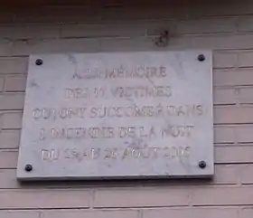Plaque commémorative apposée sur l'immeuble après sa reconstruction.