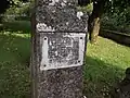 Plaque fixée sur une ancienne croix de pierre (XVIIe siècle) dans l'ancien cimetière.