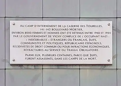 La plaque en mémoire des victimes de la caserne des Tourelles, se situe près de la rue, sur les murs de la piscine Georges-Vallerey, côté boulevard Mortier).