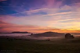 Vue depuis les coteaux nord-est du plateau de Malzéville avec le village d'Agincourt sous la brume, le Pain de Sucre en face et la colline d'Amance au fond à gauche.