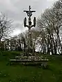 Calvaire de la chapelle Sainte-Barbe : Ange portant les instruments de la Passion entre saint Jean et saint Méen.