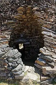 Chambre en encorbellement éventrée. On voit le débouché du couloir, avec lumière venant de l'entrée au fond de ce couloir.