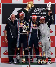Photo d'Adrian Newey, Mark Webber, Sebastian Vettel et Rubens Barrichello sur le podium de Silverstone
