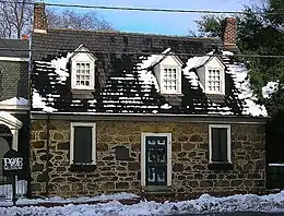 maison au fond d'un parc en partie cachée par les arbres