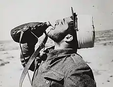 Un légionnaire de la 1re Brigade française libre étanche sa soif dans le désert, Mars 1943.
