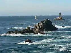 Vue du Raz de Sein à marée montante depuis la pointe du Raz avec le phare de la Vieille (à droite) et la tourelle de la Plate (à gauche) ainsi que l'île de Sein à l'horizon.