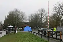 Vue de journaliste en avant plan d'un banc recouvert d'une toile bleue.