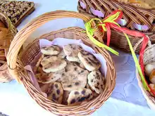 basket filled with round, flat pieces of bread with some browning and charring on the surface