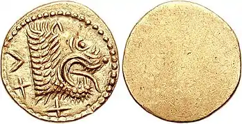 Monnaie en or recto verso avec un côté lisse et un côté avec une tête de lion tirant la langue.