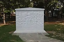 Monument blanc représentant un grand nombre de personnes dans une geôle sous laquelle est inscrite, en grec, la date du 17 novembre 1973.