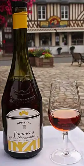 Une bouteille et un verre de Pommeau de Normandie.