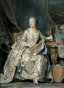 Portrait d’une femme assise dans un fauteuil, avec une robe longue.