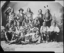 Photographie en noir et blanc d'un groupe d'Amérindiens en habit traditionnel.