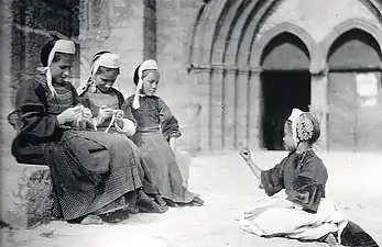 Fillettes faisant du crochet devant l'église des Carmes de Pont-l'Abbé (1900, photographie de Constant Puyo).