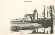 L'église Saint-Michel se reflétant dans les eaux de la Touques vers 1910.