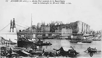 Carte postale ancienne montrant un pont suspendu, avec des navires en bois au premier plan, le château et la ville à l'arrière-plan.