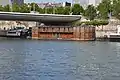 Sous le pont est amarrée la péniche l'Adamant, hébergeant un hôpital psychiatrique sur la Seine.