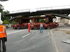 Déplacement de l'ancien tablier, lourd de 650 tonnes, vers le chantier de l'entreprise sur des remorques Kamag.