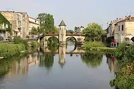 Photographie d'une rivière avec un pont en arrière-plan.