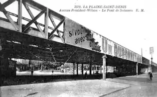 Le pont vers 1920. en direction du centre de Saint-Denis. Les lignes électrifiées du tramway passant sous le pont sont visibles.