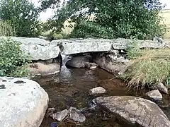 Vieux pont traditionnel fait de grosses dalles de pierre sur le ruisseau de Grezettes.