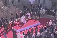Le pape François célèbre une messe dans la rue sur fond de bâtiments détruits