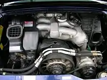 Compartiment moteur d'une 911 équipée du moteur de 285 ch, le collecteur d'admission en acier est visible sur la partie haute du moteur.