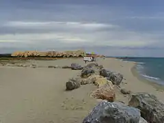 La plage naturiste avec vue sur des résidences.