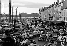 Photo en noir et blanc d'un port provençal très fréquenté.