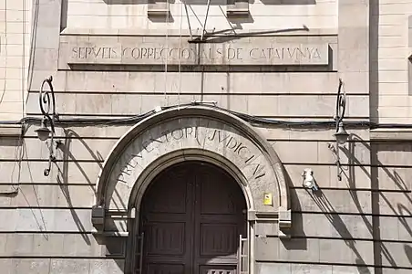 Porte principale de la prison (carrer Entença) avec l'inscription « Services Correctionnels de Catalogne ».