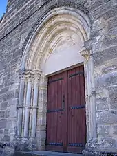 Portail principal de l'église, en arc brisé et à chapiteaux ornés de motifs végétaux