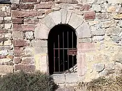 Porte de l'église entourée de blocs de marbre local.