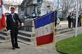 Porte-drapeau du 9e régiment de chasseurs parachutistes devant le monument aux morts de Laval (mars 2012).