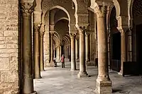 Vue intérieure du portique sud qui sert de narthex à la salle de prière. Les colonnes, qui soutiennent des arcs outrepassés brisés, présentent des bases et des chapiteaux variés.