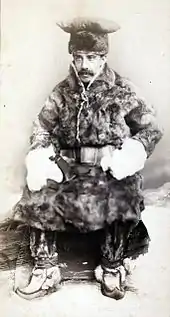 Photographie en noir et blanc d'un homme vêtu de fourrures.