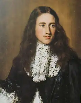 portrait d'un homme aux cheveux longs portant de la dentelle sur un habit noir satiné.