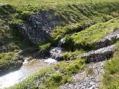 Fossé ou noue renforcé par des gabions pour résister à des flux torrentiels et/ou protéger des sols fragiles, notamment des rats musqués.