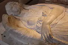 Vue rapprochée du couvercle sculpté d'un sarcophage.