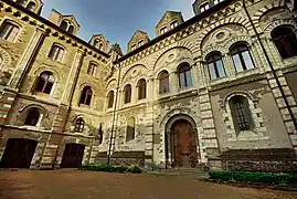  Photographie d'un presbytère médiéval en tuffeau, façade sur cour.