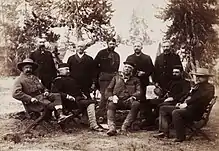 Photographie d'un groupe d'hommes assis dans une foret