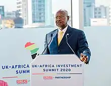 Chef d'État africain en costume et cravate s'adressant à un public lors d'une conférence